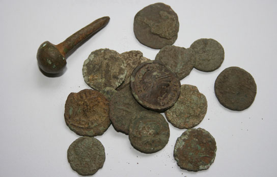 A baluster headed Roman pin 2nd Century AD along with a selection of small Roman coins some showing the Emperors Tetricus and Crispus. It can be seen by their overall condition just how vital it is to recover these coins now.